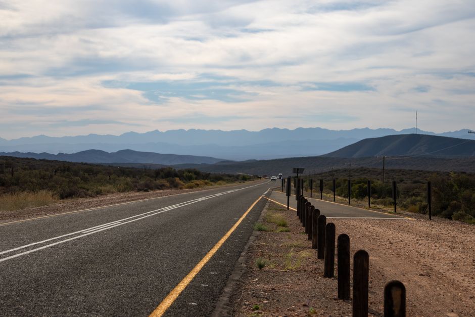 Un autobus a lunga percorrenza che viaggia lungo un'autostrada inglese, con campagna verde e segnali stradali in vista