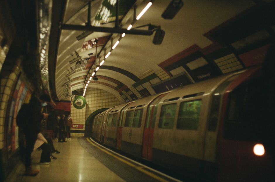 Vilkas Lontoon metroasema Tube-junan saapuessa, ikoninen roundel-asemakyltti etualalla