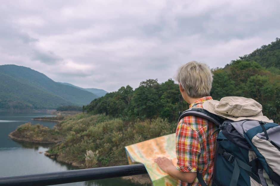 Reissu selässään reppineen katsomassa Highland-laaksoon ja suunnittelemassa reittiä paperikartalla