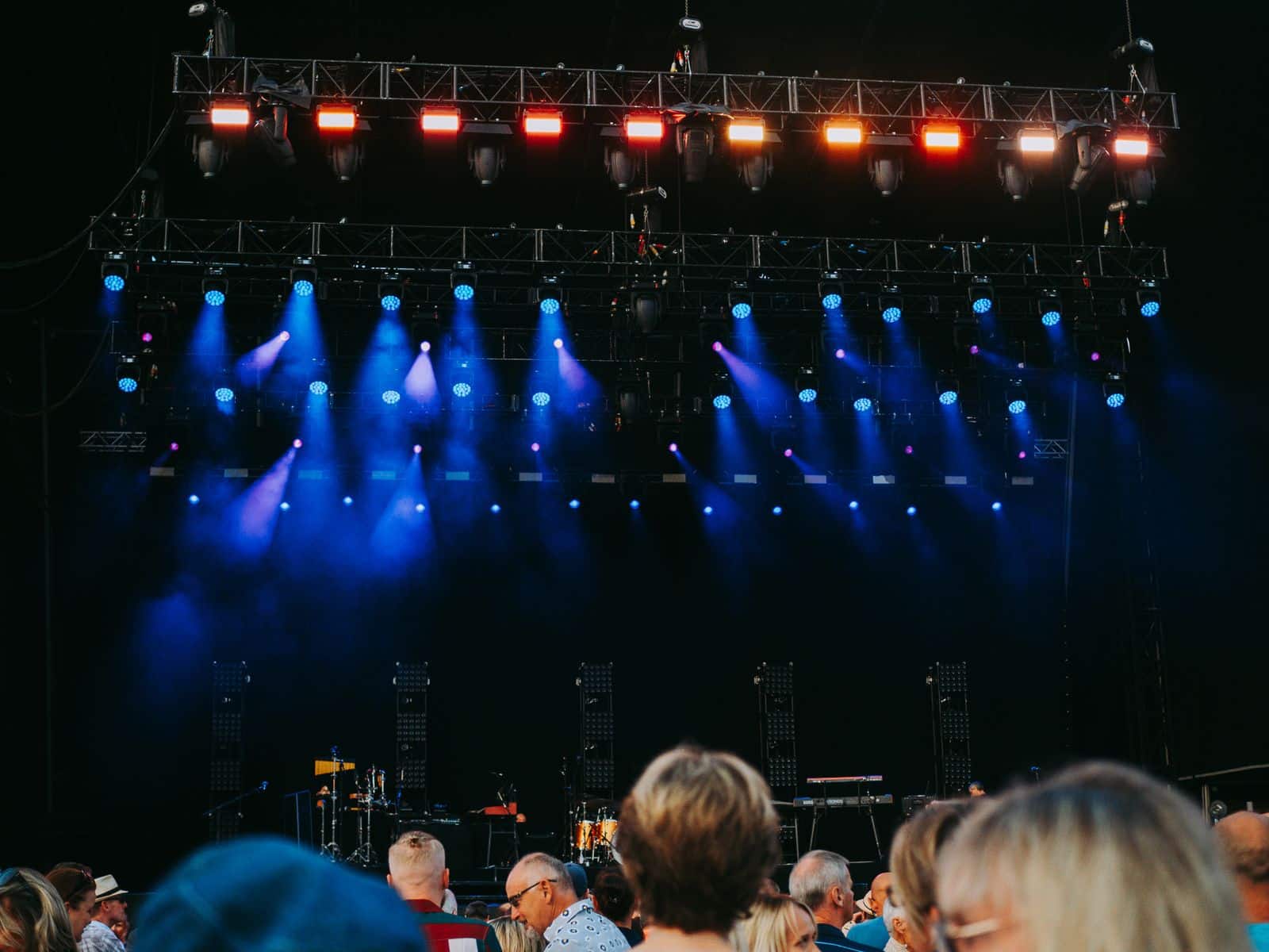 Suuri konsertin yleisö kirkkaasti valaistussa lavalla yöllisen elävän musiikin esityksen aikana