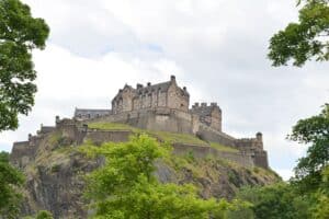 Edinburgh Castle above the city rooftops during the summer Edinburgh Festival Fringe season