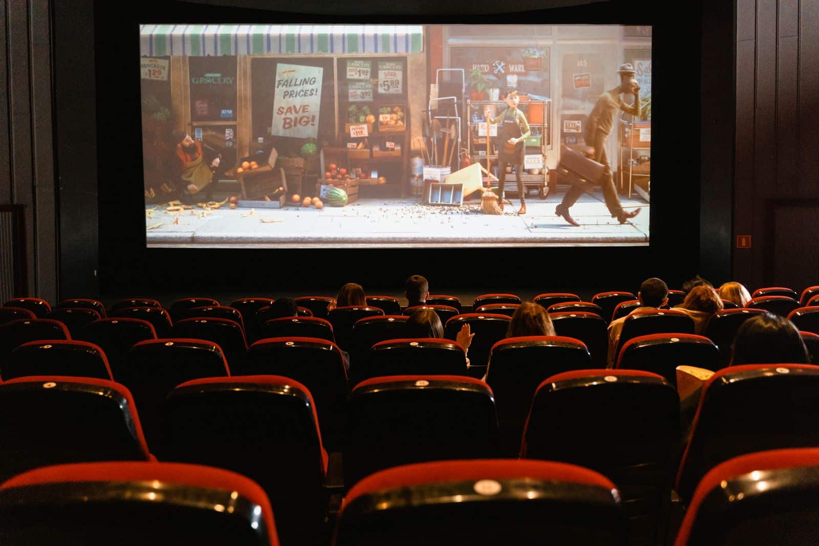Yleisö istuutuu pimeässä teatterissa seuraamassa live-esitystä festivaalilla