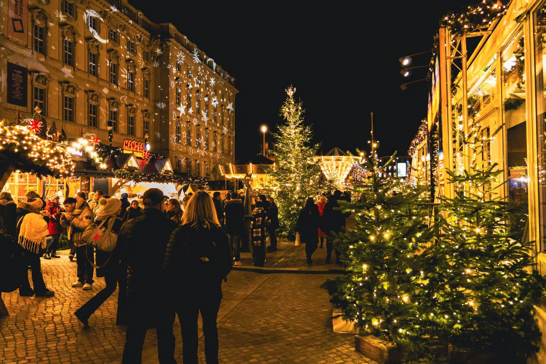 Casetas de mercado navideño de madera iluminadas por la noche en el centro de una ciudad británica
