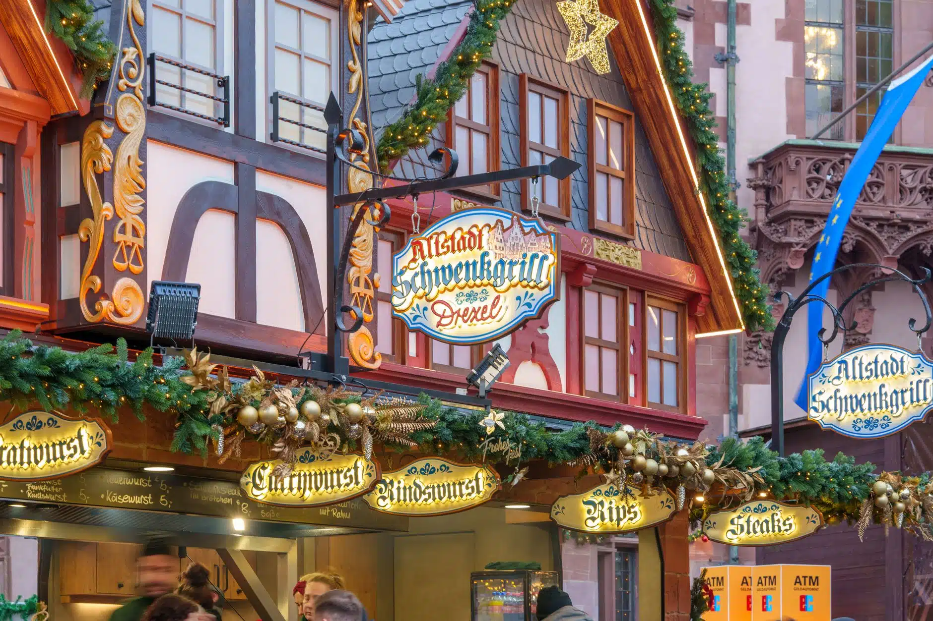 Puesto de comida asando salchichas bratwurst en un mercado navideño británico de estilo alemán