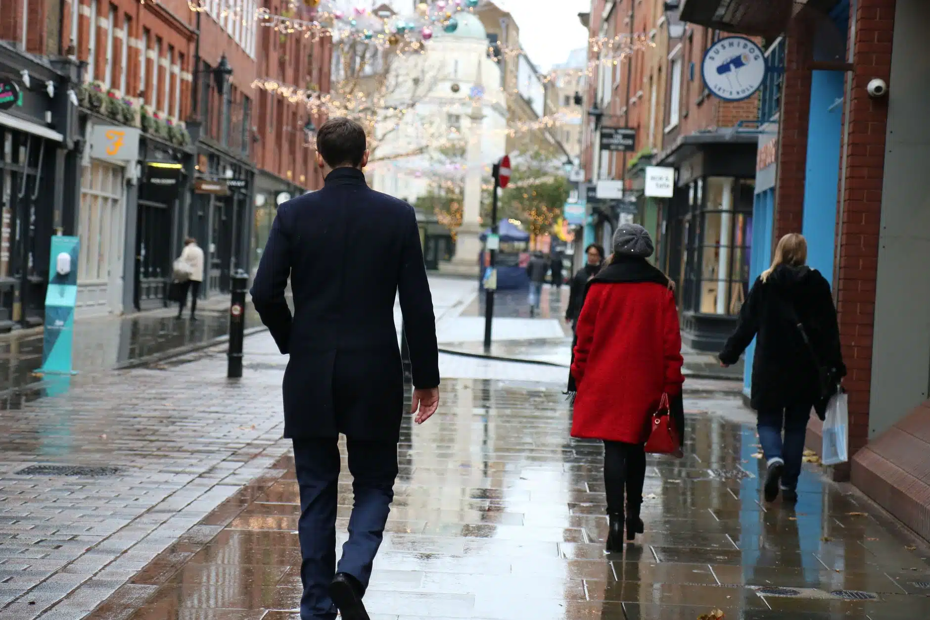 Viajero con abrigo de invierno cálido en una fría calle de ciudad británica en diciembre