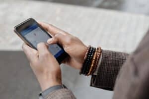A visitor using a phone to plan travel on a busy London street
