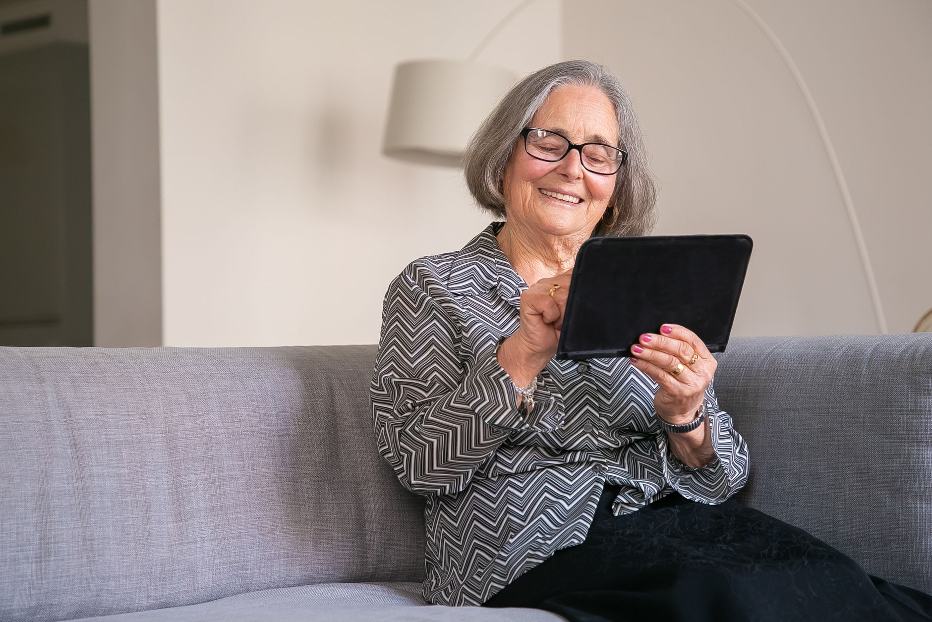 An older traveller being helped to complete an online travel form on a tablet